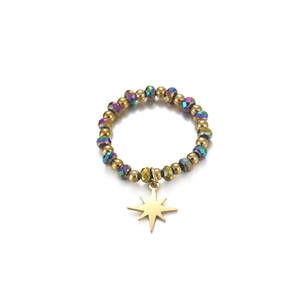 Detailed macro view of beaded daisy ring with gold beads and an eight-pointed star charm