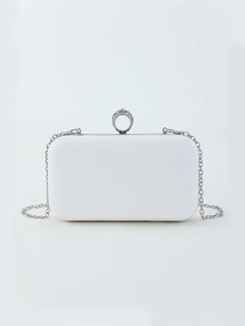 Detailed view of white bridal clutch bag with rhinestone ring clasp and silver chain strap
