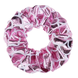Detail of pink metallic hair scrunchie with white geometric pattern and glossy texture