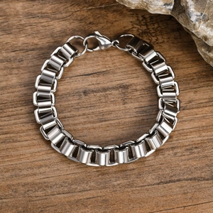 Close-up of silver stainless steel chain bracelet with lobster clasp on rock background