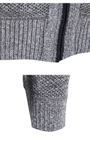 Detail of gray knit sweater showing ribbed cuffs and coarse texture hemline close-up