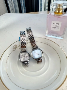 Detail view of silver square quartz watches with metal strap on a white decorative plate