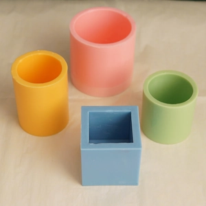 Detailed view of four colorful silicone candle molds in round and square shapes