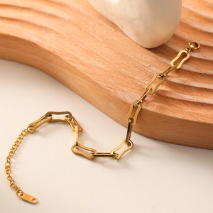Adjustable 18k gold plated stainless steel geometric chain bracelet on a wooden stand