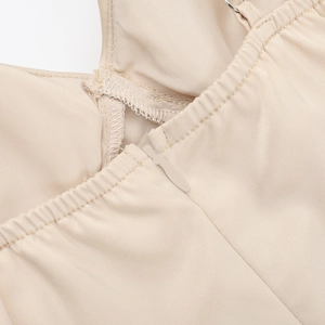 Détail d'une fermeture éclair invisible et couture sur robe de vacances en satin