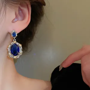 Vintage oval dark blue zircon earrings with ornate gold and silver woven metal frame