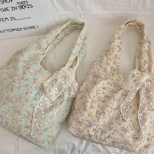 Detailed look of floral canvas bags with lace trim and large bows in green and white colors