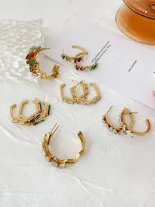 Detail view of five pairs of irregular titanium steel hoop earrings with colorful zircon stones