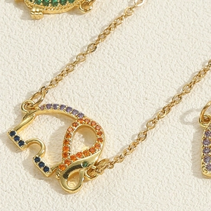 Detailed macro view of golden elephant pendant with vibrant multi-color zircon stones