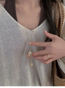 Detail of adjustable 18k gold plated Y-necklace with liquid metal style pendants