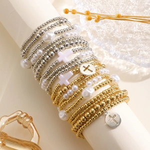 Dettaglio di bracciali di perline fatti a mano multistrato con croci e perle su un supporto