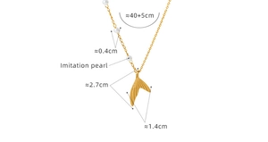 Detail view of a gold mermaid tail pendant with white imitation pearl and size labels