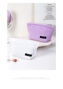 Detail of soft corduroy makeup bags in purple and white with vertical stripe texture