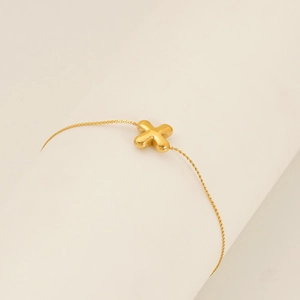 Macro shot of gold cross pendant with 18K gold plating on a minimalist link chain