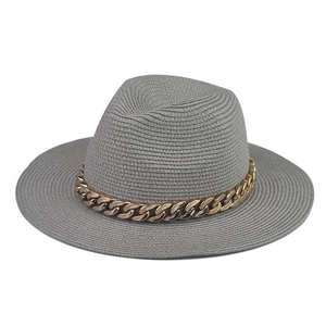 Detailed texture of grey straw fedora hat featuring a chunky decorative gold chain strap