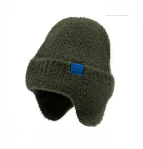 Vue détaillée du bonnet en maille vert foncé avec étiquette tissée au motif de flocon