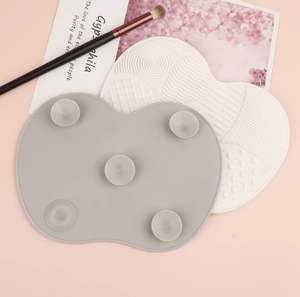 Detailed view of grey and white textured silicone makeup brush cleaning pads with suction cups