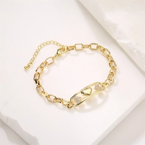 Detailed view of golden heart-shaped bracelet with zircon inlay on a stone surface