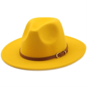 Detail of yellow wool fedora hat featuring a brown leather band and gold metal buckle