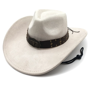 Dettaglio della fibbia in metallo a testa di toro e rivetti sul cappello da cowboy beige