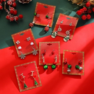 Detail view of festive Christmas earrings set featuring tree, bell and snowman designs