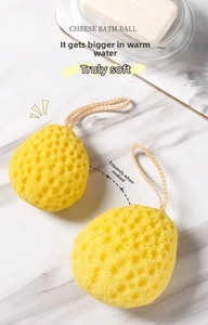 Detail of yellow cheese-shaped bath sponge showing honeycomb texture and water expansion
