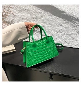 Detail of green PU leather handbag with crocodile texture and detachable shoulder strap