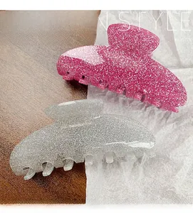 Detail of glitter resin hair claw clips in sparkling pink and silver with sturdy teeth