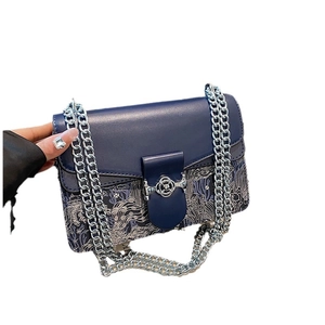Elegant blue chain shoulder bag with intricate silver embroidery and floral clasp detail