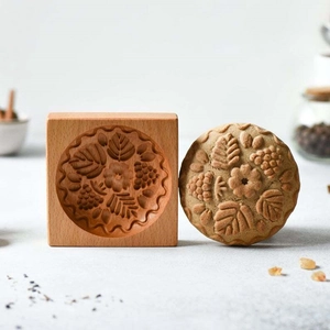 Rectangle beech wood cookie mold featuring intricate floral carving with a finished biscuit