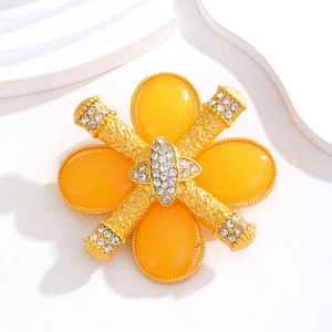 Macro shot of baroque flower brooch with yellow resin stones and sparkling rhinestones