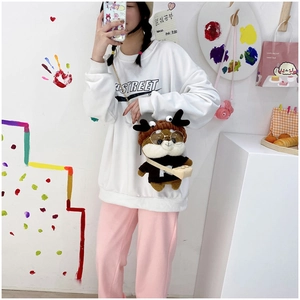 Cute Shiba Inu plush crossbody bag worn by a model against a decorative background wall