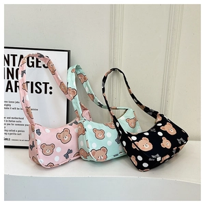 Detailed view of three cute cartoon bear shoulder bags in pink, green, and black colors