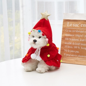 Detail of red pet Christmas tree cape with golden star and colorful plush ball decor