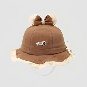 Detail of baby sun hat featuring bear ears, bow, and adjustable windproof strap