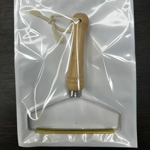Portable lint remover with wooden handle and copper head in transparent packaging