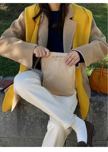 Close-up of brown Perment Bake Shop paper bag held by woman in winter outfit