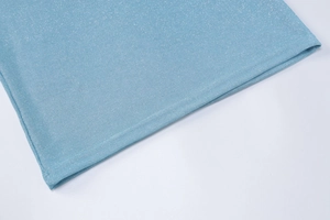 Detail von hellblauem Kleiderstoff mit glitzerndem Silberglitter und feinen Nähten am Saum