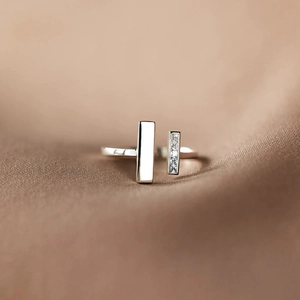 Close-up of a minimalist square open ring with polished silver finish and zircon inlay