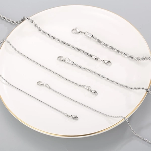 Multiple silver twisted rope chains in various sizes displayed on a ceramic white plate