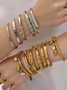 Detailed view of stacked stainless steel bangles and bracelets with 18k gold plating