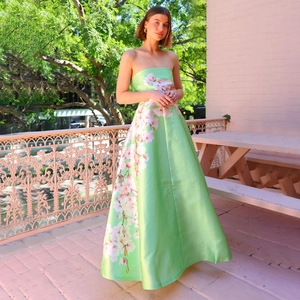 Detailaufnahme des mintgrünen Satin-Abendkleids mit zarten floralen Drucken und Glanz
