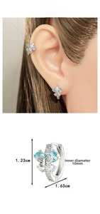 Détail d'une boucle d'oreille papillon argentée avec zircon bleu et diamètre de 10 mm