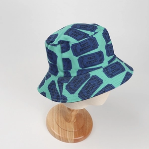 Detailed view of mint green bucket hat with blue ticket print on wooden stand