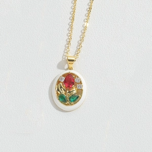 Detail showing vintage gold flower pendant with zircon stones and white enamel inlay