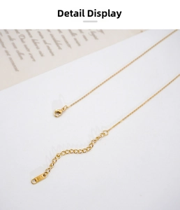 Close-up of gold lobster clasp and adjustable extension chain with K18 engraved tag