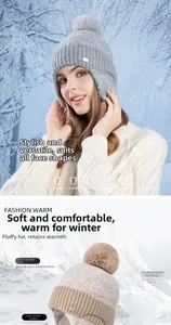 Detail of winter knitted hat with thick fleece lining and fluffy faux fur pompom