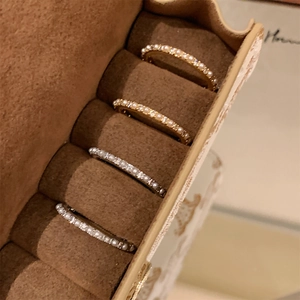 Detailed macro of 14K gold and silver rings with pearls in a brown jewelry box