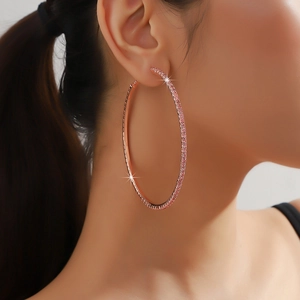 Close-up of oversized rose gold hoop earrings with sparkling pink pave rhinestones