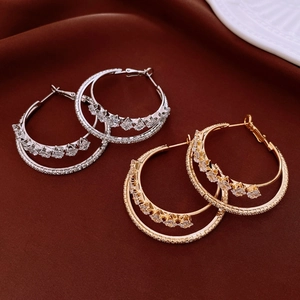 Detail view of double hoop earrings with cubic zirconia on deep red velvet background